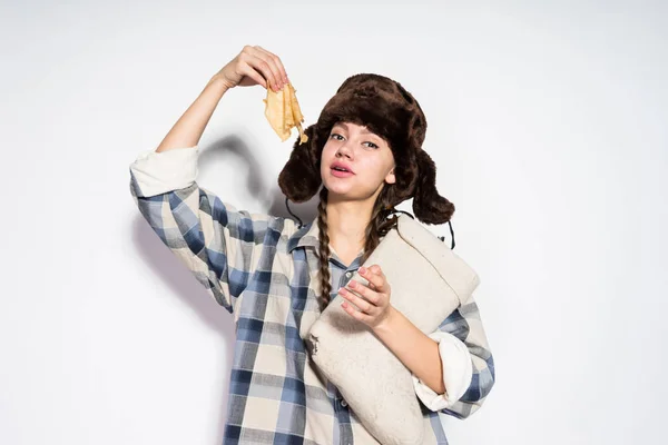 Rosyjski dziewczyna w kapeluszu ciepłe futro jeść pyszne naleśniki, zapusty świętuje — Zdjęcie stockowe