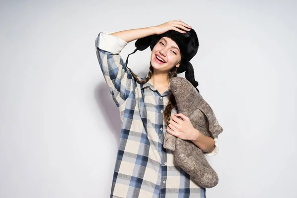 Happy young russian girl holding gray felt boots in hands — Stock Photo, Image