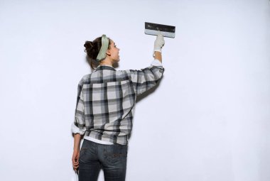 genç kız ressam ekose gömlekli bir spatula ile duvarlar tesviye, evde tamir