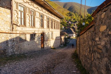 yüksek dağlar arka planda dar sokak