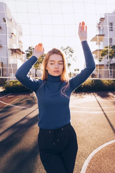Nachdenklich schöne Frau posiert vor der Kamera auf dem Volleyballplatz, Frühling, sonniger Tag — Stockfoto