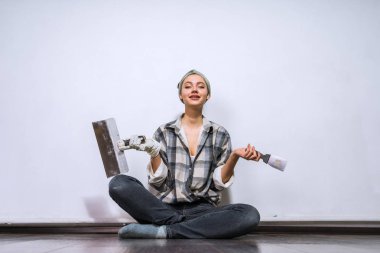 bir daire tamir boya duvarlar için bir fırça tutan yorgun bir kadın