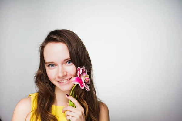 Glückliche schöne Frau mit einer Tulpe, am 8. März, Hintergrund für eine Grußkarte — Stockfoto