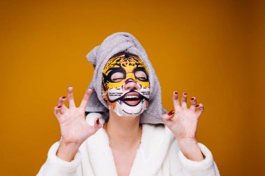 kafa havluya ile mutlu kadın duştan sonra yüzünde, nemlendirici maske uygulamak