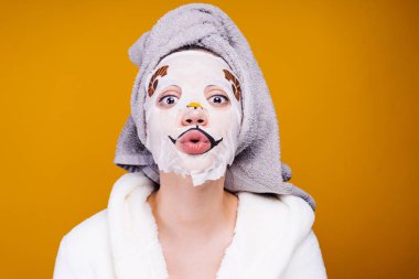 Kafasındaki bir havlu ile kadın duştan sonra yüzünde, nemlendirici maske uygulamak