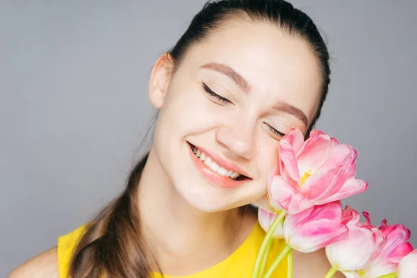 Happy woman holding a bouquet of flowers, tulips, on March 8, mother's day — Stock Photo, Image