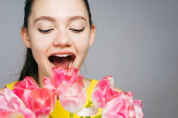 3 월 8 일, 인사말 카드에 대 한 배경에서 그녀의 손에 꽃의 꽃다발을 들고 행복 한 아름 다운 여자 — 스톡 사진