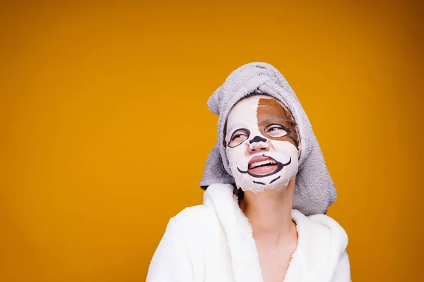 Šťastná žena dát nebo vykreslen zvlhčování nebo smáčení masku na obličej a vypadá stranou — Stock fotografie