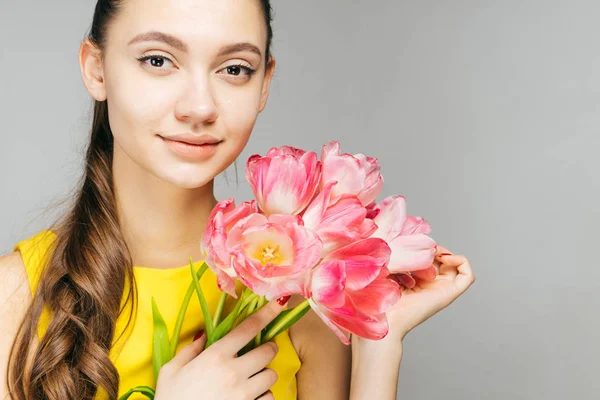 Beautiful woman holding a bouquet of tulips in her hands, mother's day — Stock Photo, Image