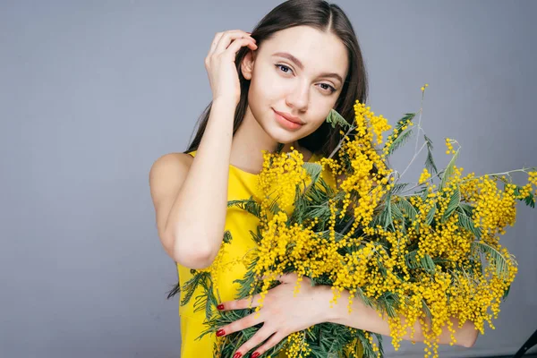 La mujer asombrada sosteniendo un ramo de flores amarillas, 8 de marzo, Día de la Madre — Foto de Stock