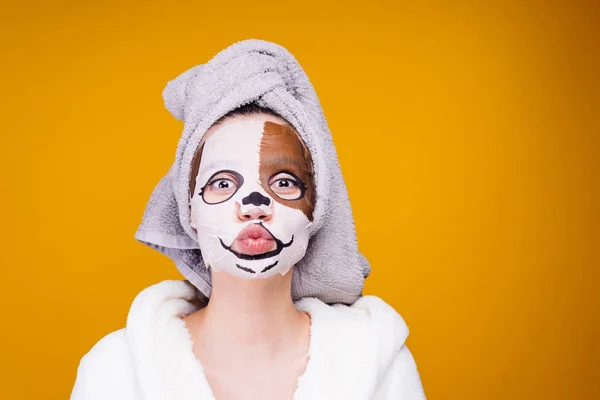 Kvinna med en handduk på huvudet Applicera en återfuktande mask på ansiktet — Stockfoto