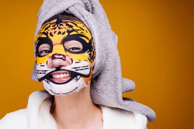 mutlu bir kadın koymak veya bir nemlendirme veya ıslatma maske yüzünde aptal sonra işlenen