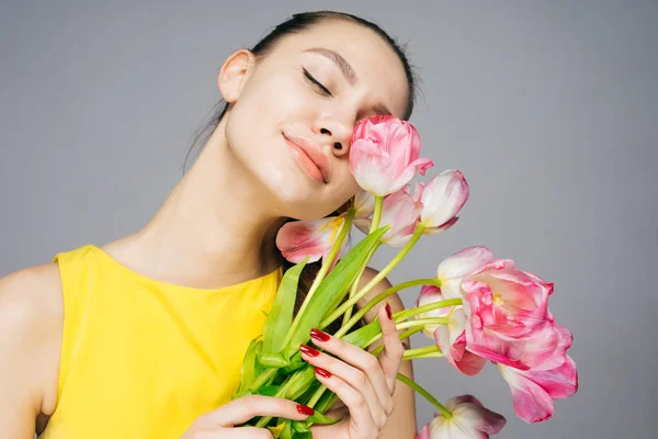 The amazed woman holding a bouquet of tulips in her hands, on March 8 — Stock Photo, Image