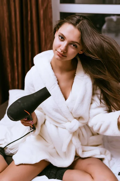 Vrouw in de ochtend droogt haar haar — Stockfoto