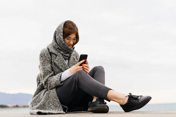 Woman walking outdoors looking at phone — Stock Photo, Image