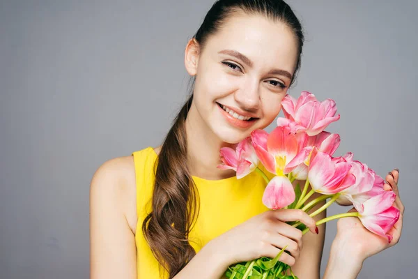 Bir buket çiçek tutan eller, 8 Mart kadın günde mutlu genç güzel kadın — Stok fotoğraf