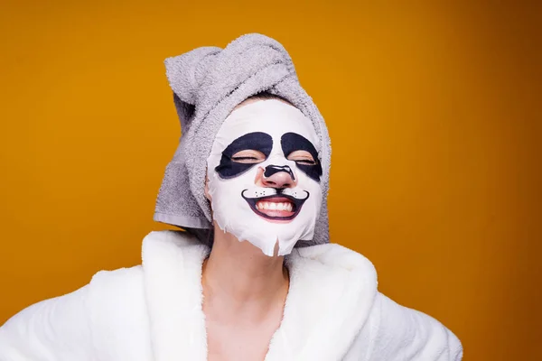 Mujer feliz con una toalla en la cabeza aplicar mascarilla hidratante en la cara — Foto de Stock