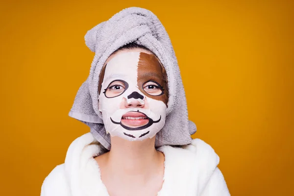 Kvinna med en handduk på huvudet Applicera en återfuktande mask på ansiktet — Stockfoto