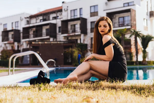 Bella donna ricca seduta vicino alla piscina sullo sfondo della villa — Foto Stock