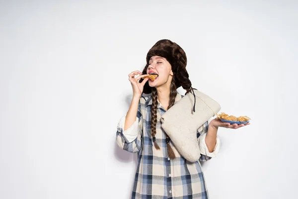 Chica rusa comiendo panqueques sobre un fondo gris — Foto de Stock