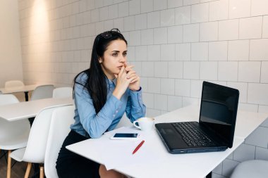 Office masada oturan dalgın kadın