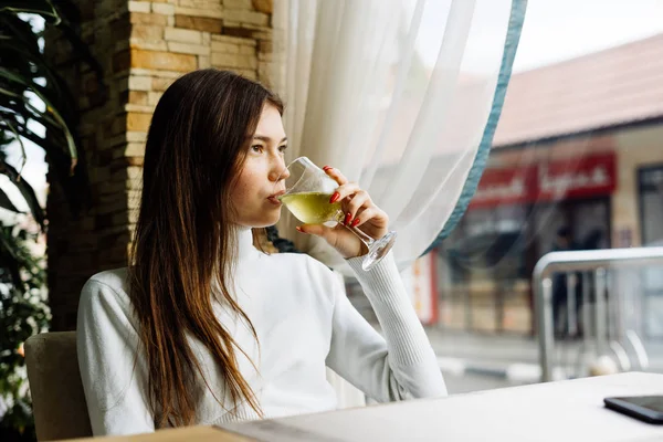 Sad beautiful rich woman drinking white wine — Stock Photo, Image