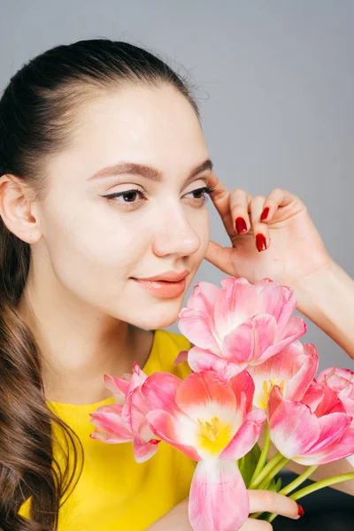 Mujer pensativa sosteniendo un ramo de tulipanes en sus manos, 8 de marzo, día de la mujer — Foto de Stock