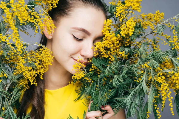 Donna felice che tiene fiori gialli in mano — Foto Stock