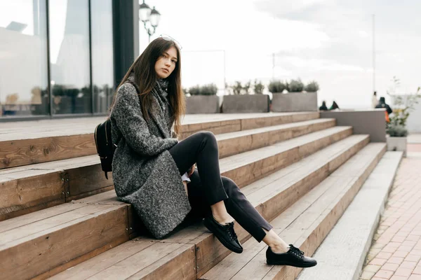 Belle jeune femme assise sur les marches, mode de rue — Photo