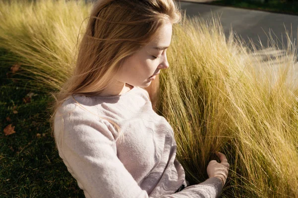 Beautiful young woman on grass background in spring — Stock Photo, Image