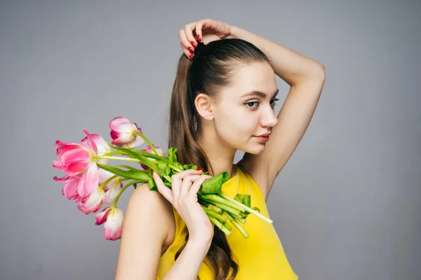 A thoughtful woman holding a bouquet of tulips in her hands, March 8, mother's day — Stock Photo, Image