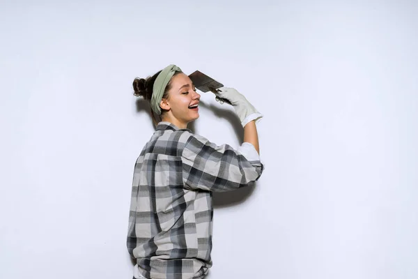 Happy woman holding a spatula in hands, repairing an apartment — Stock Photo, Image