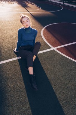 güzel bir kadın oturur bir futbol mahkeme, sokak moda, Bahar