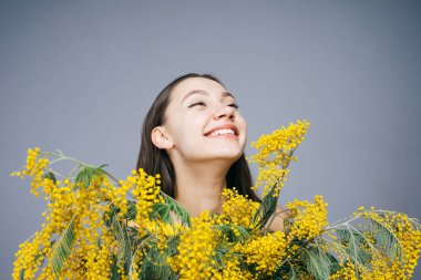 mutlu kadın sarı çiçekler bir arka plan karşı poz