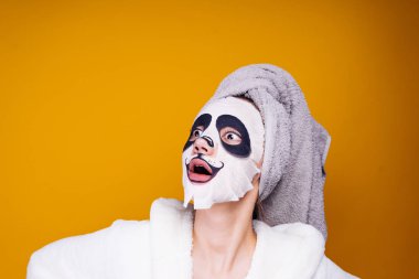 bir duş yüzü, bir panda şeklinde bir nemlendirici maske koyar sonra bir kadın