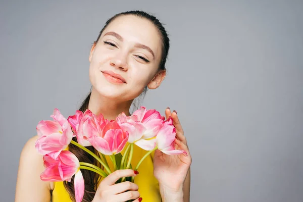 Gelukkige vrouw met een boeket bloemen in haar handen, Moederdag, vrouwelijke dag. — Stockfoto