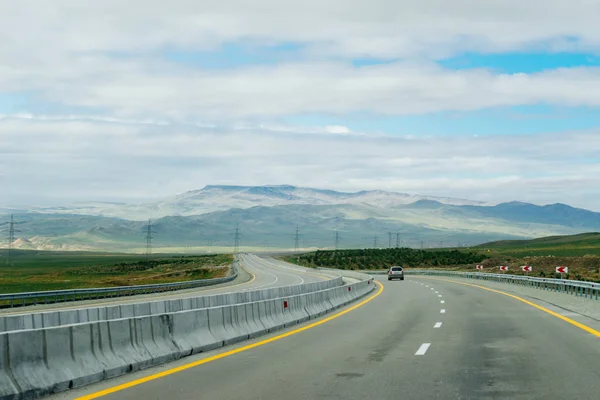 Road, a highway at the foot of the mountains — Stock Photo, Image