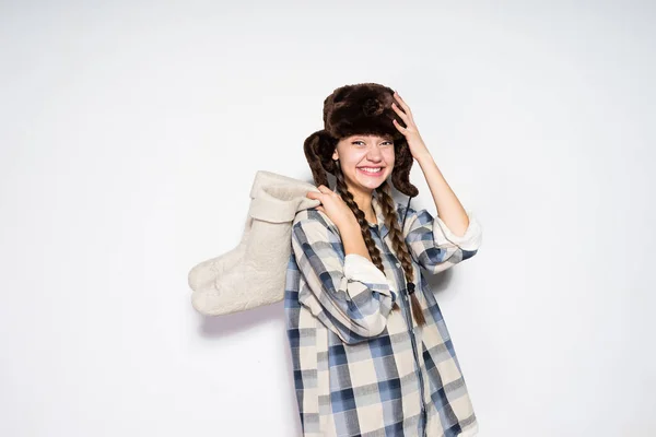 Mujer feliz sosteniendo botas de fieltro en frente de fondo blanco — Foto de Stock