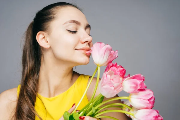 Happy woman holding a bouquet of flowers in her hands and sniffing them, mother's day, women's day, March 8 — Stock Photo, Image