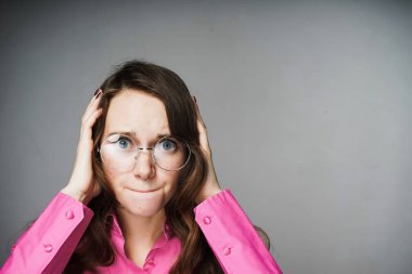 Kız kulaklarını elleriyle kaplı.