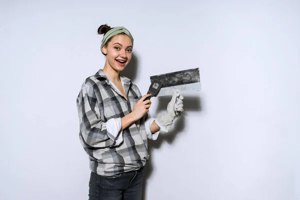 Девушка держит лопатку, делает ремонт в квартире — стоковое фото