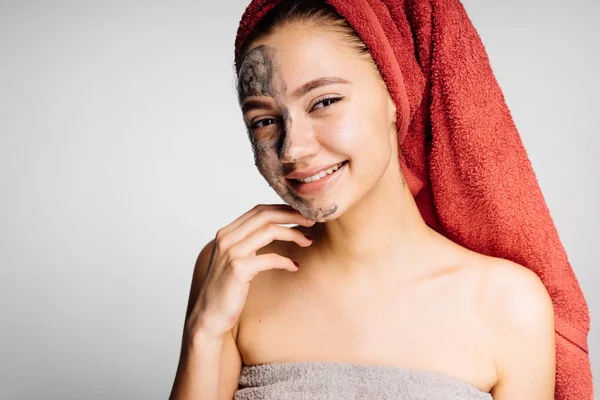 Flicka tillämpas en lermask till halva ansiktet — Stockfoto