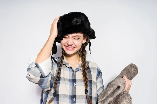 Chica de Rusia en un sombrero de piel caliente sostiene botas — Foto de Stock