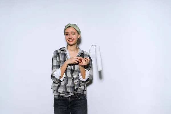 Meisje schildert de muren in het wit met een roller — Stockfoto