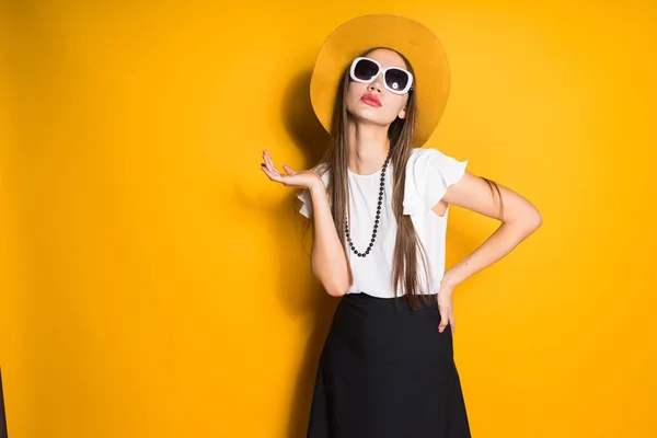 Menina em óculos de sol e chapéu posando no fundo — Fotografia de Stock