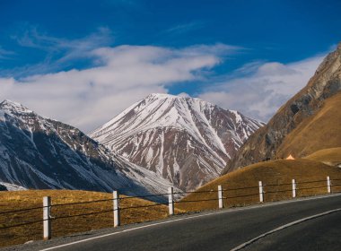 yüksek dağlar, sarı alanlar ve mavi gökyüzü