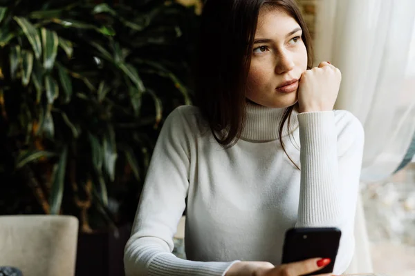 Chica sentada en un café, mirando por la ventana —  Fotos de Stock