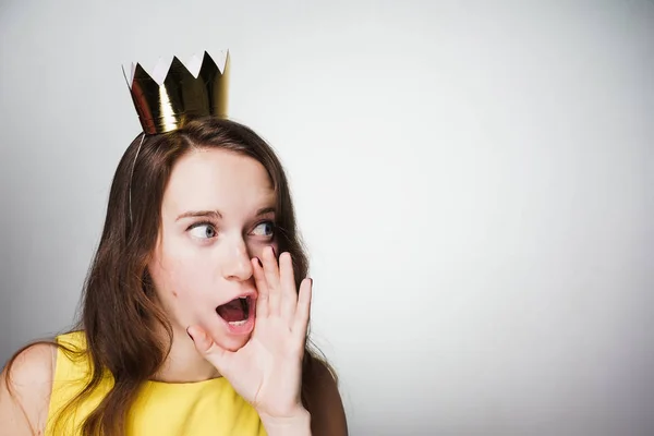 Женщина выглядит удивленной и кричит, золотая корона — стоковое фото