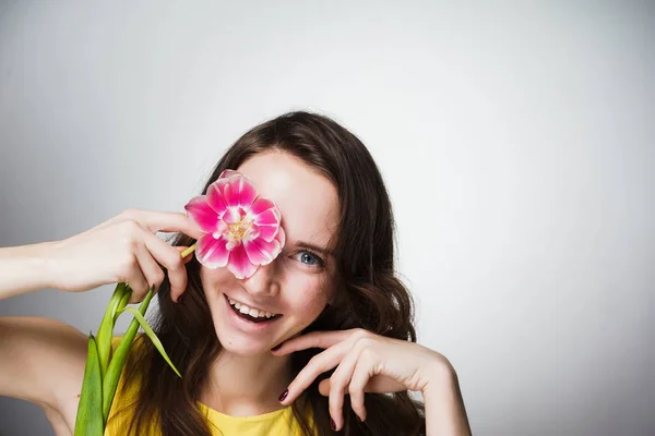 Niña sostiene una flor, el día de la mujer del mundo — Foto de Stock