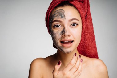 Kız bir kil maskesi yüzünün yarısı koyar